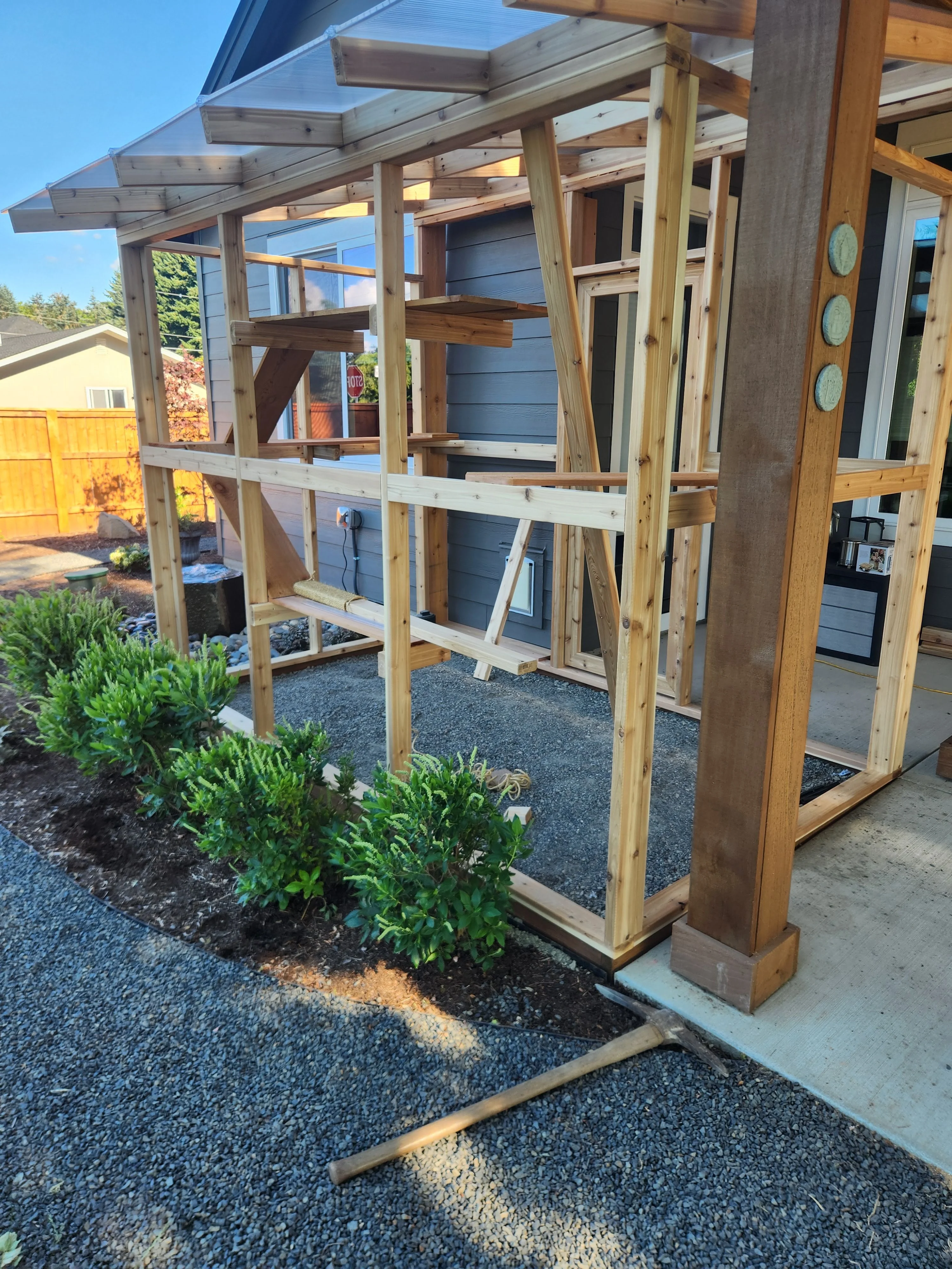 Outdoor catio enclosure framing beside a home
