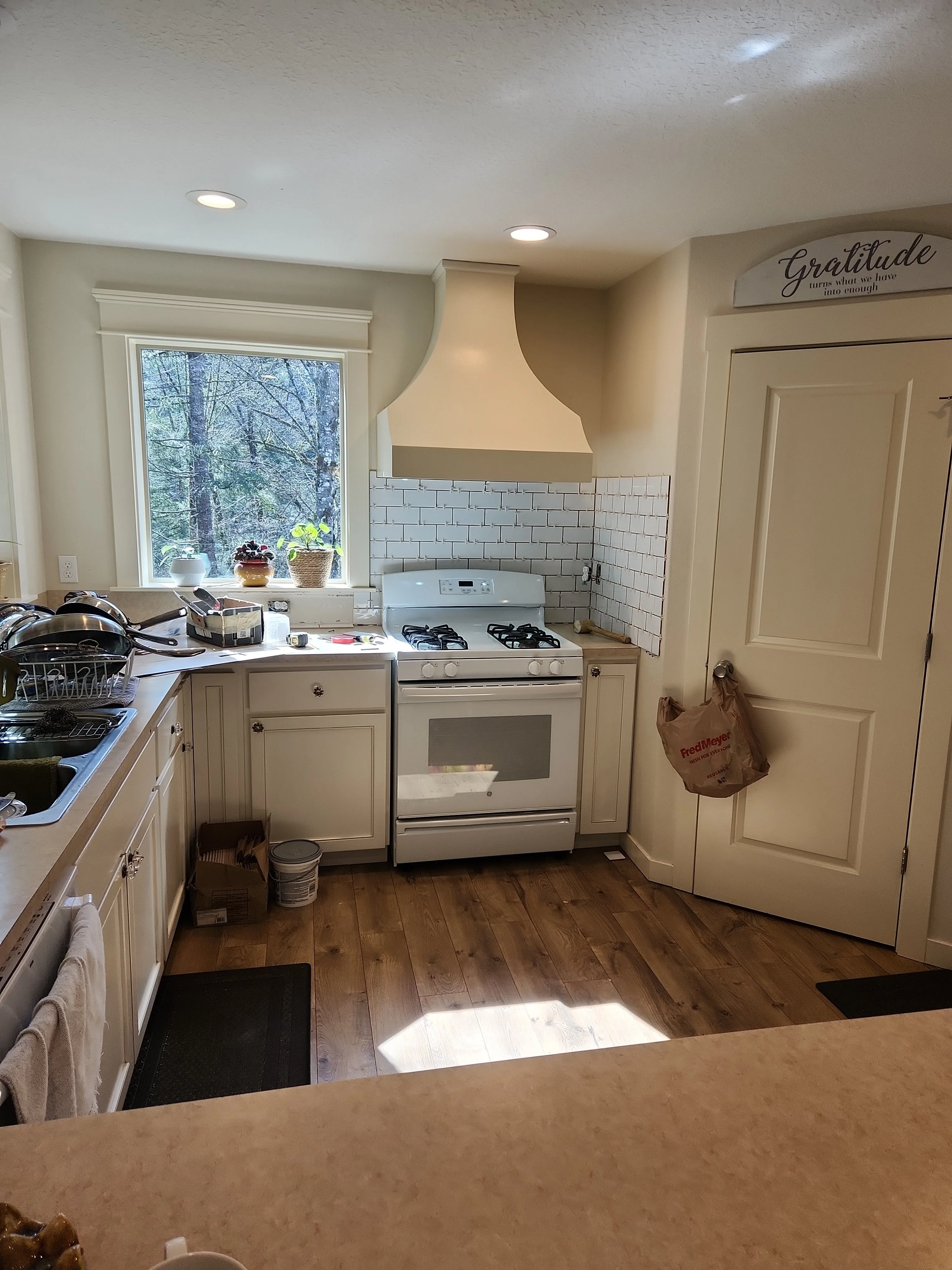 Finished kitchen with backsplash, cabinets, and range area
